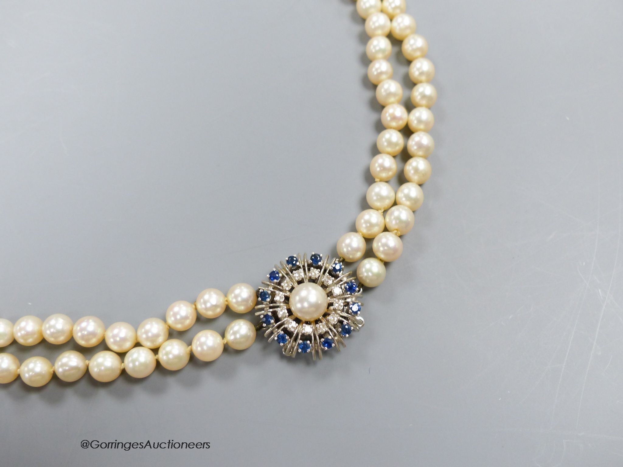 A two strand cultured pearl choker necklace with sapphire and diamond set 14k white gold clasp, length 40cm